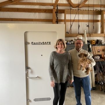 couple with dog standing in front of their new family safe